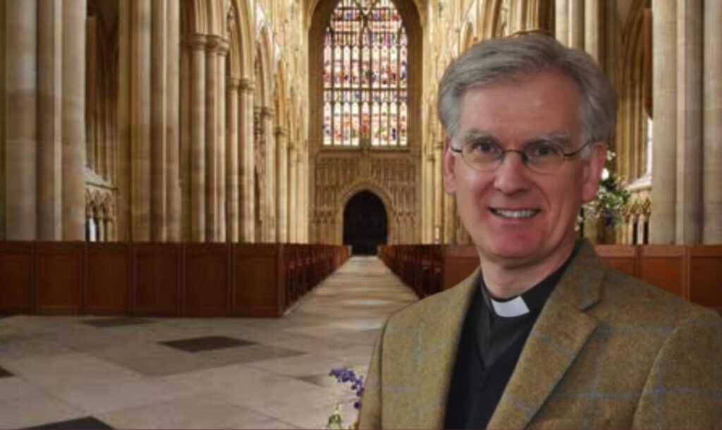 The Vicar standing in the Nave of the Minster.
