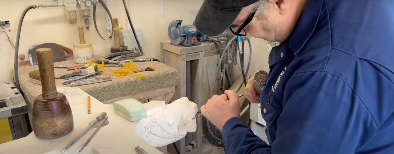 A Minster stonemason carving stone in the workshop.